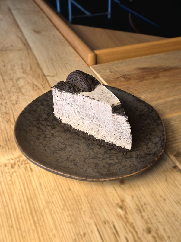 A delicious slice of Oreo Cheesecake with golden cookie crust and creamy filling